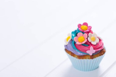 Renkli çiçek ve yaprak beyaz tahta masada closeup kek krem renkli top ile süslenmiş. Kadın ya da anneler günü için Bahar pasta