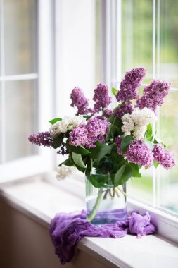 Gün ışığında pencereyakınında cam vazo güzel leylak Bahar ihale buket