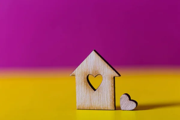 Closeup maison en bois avec trou en forme de coeur sur fond cramoisi vibrant et jaune . — Photo