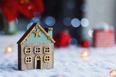 Kırmızı ev şenlikli dekor ve gün ışığında bulanık bokeh arka plan ile altın yıldız kapalı closeup sevimli Noel kış evi.