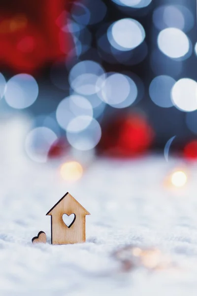 Деревянная икона дома с отверстием в форме сердца с красным домом рождественский декор и размытый боке фон при дневном свете . — стоковое фото