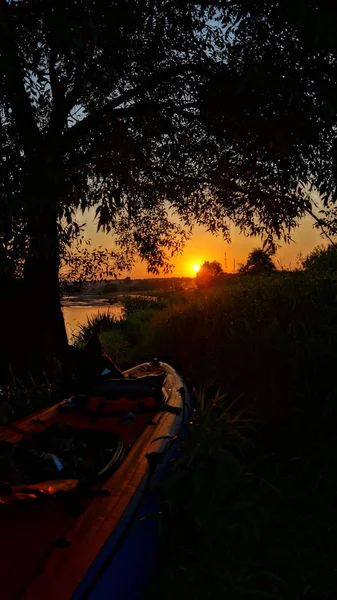 Bir kayık içinde Nehri'nde rafting. Sakin nehir, yeşil alanları ve ormanları çevresinde. Kırsal kesimde iyi tatiller. Büyük spor hafta sonu. Akşam sahile iskelede. Güzel gün batımı