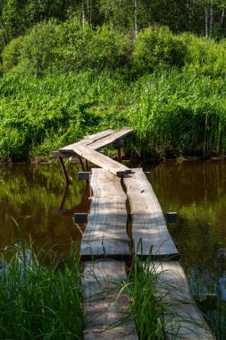 Sakin küçük nehrin üzerinde tahta köprü