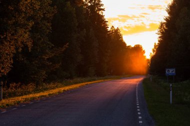 Yazın boş bir yolda güzel bir gün batımı