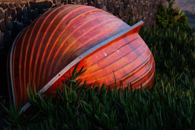 turuncu tekne yeşil çimlerin üzerinde duruyor