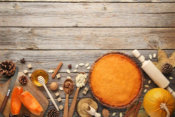 Pumpkin tart with honey, sugar and seeds on wooden table
