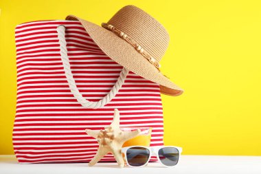 Şapka ve güneş gözlüğü sarı zemin üzerine yaz çanta