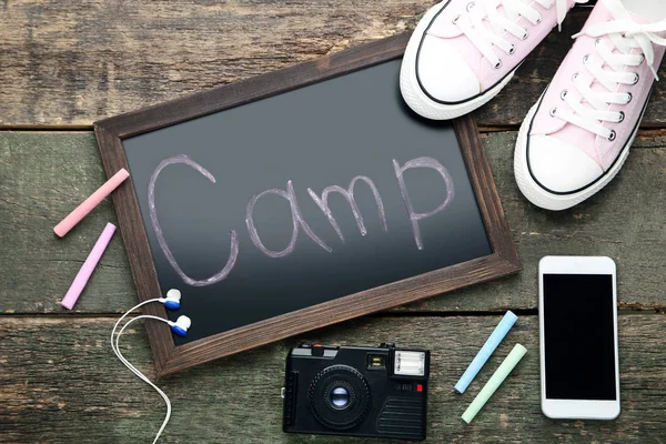 Inscription Camp Mit Smartphone Retro Kamera Und Sportschuhen Auf Holztisch — Stockfoto