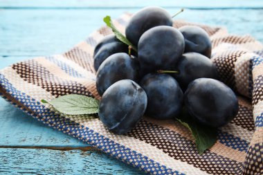 Olgun ve tatlı Erik mavi ahşap masa peçeteye ile