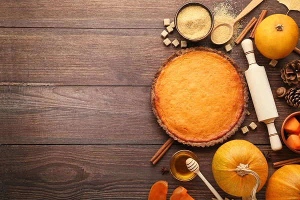 Pumpkin tart with honey, sugar and cinnamon on wooden table