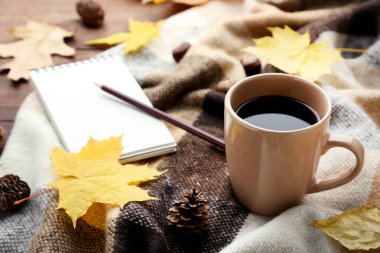 Kahve ekose ve ahşap masa üstünde defter ile