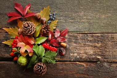 Çilek ve ahşap masa üzerinde fındık ile sonbahar yaprakları