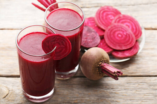 Fresh beets juice in glass on a wooden background