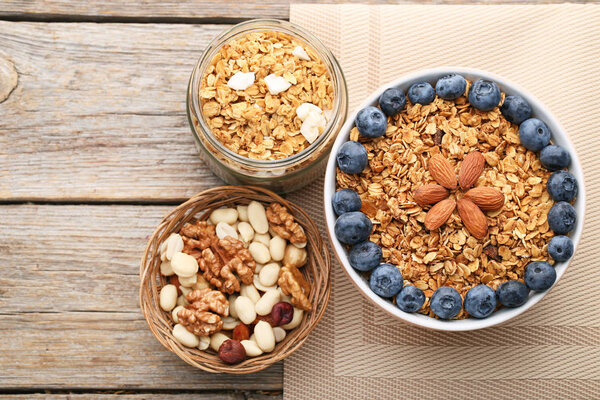 Вкусная мюсли в миске с черникой и миндалем на деревянном столе
