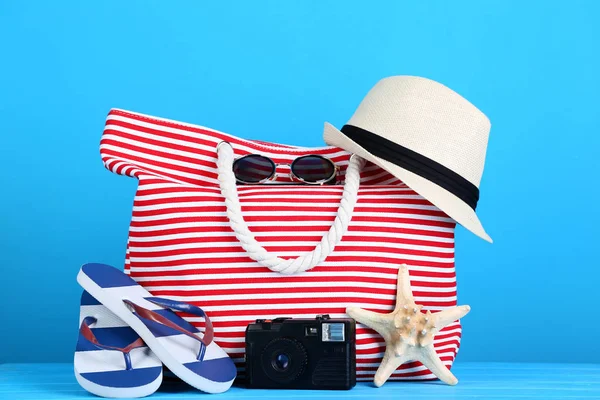 Plaj aksesuarları ile mavi arka plan üzerinde retro fotoğraf makinesi