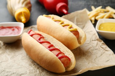 Hardallı sosisli sandviç ve ahşap masada ketçap.