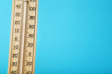 Mavi arka plan üzerinde ahşap termometre