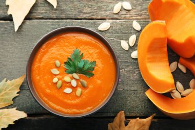 Tohum ve maydanoz ahşap masa üzerinde kase kabak çorbası