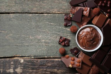 Çikolata parçaları ile fındık ve çikolata yapıştırma ahşap masa üzerinde kase