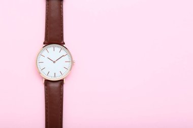 Pastel pembe bir arka plan üzerinde kol saati