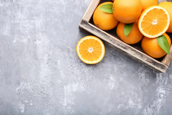 Sinaasappels Met Groene Bladeren Krat Grijze Stenen Tafel — Stockfoto