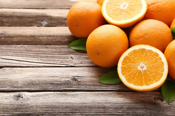 Апельсины Зелеными Листьями Коричневом Столе — стоковое фото