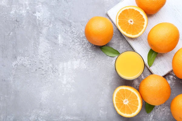 灰石桌上放有玻璃汁的橘子 — 图库照片