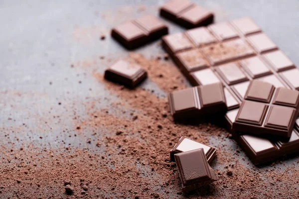 Ahşap masa üzerinde kakao tozu ile çikolata parçaları