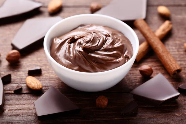 Chocolate Derretido Tazón Con Nueces Canela Sobre Mesa Madera —  Fotos de Stock