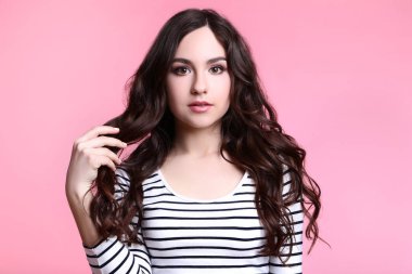 Pembe bir arka plan üzerinde çizgili bluz genç kadın portresi