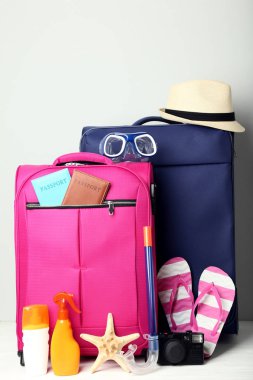 Parmak arası terlik, pasaport, ahşap masa deniz yıldızı ve güneş koruyucu şişe mavi ve pembe çantayla