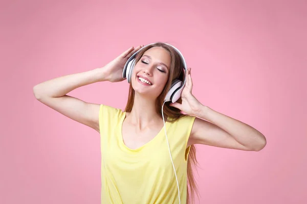 stock image Portrait of young woman with headphones on pink background