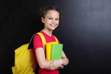 Blackboard arka plan üzerinde sırt çantası ile genç kız