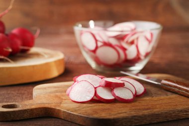 Kesme tahtası üzerinde kırmızı turp dilimlenmiş