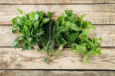 Kahverengi ahşap masa üzerinde farklı taze otlar