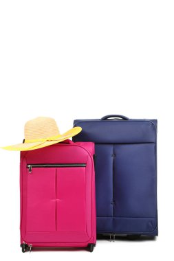Beyaz arka plan üzerinde izole şapka ile mavi ve pembe valiz