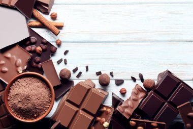 Çikolata parçaları ile kase ve ahşap masa üzerinde tarçın kakao tozu