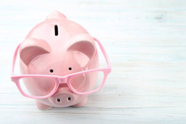 Ahşap masa gözlüklerle pembe kumbara