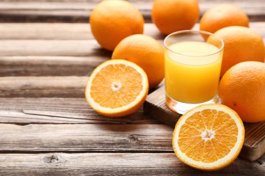 Turuncu meyve suyu kahverengi ahşap masa üzerinde cam ile