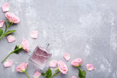 Parfüm şişesi ile gül ahşap masa üzerinde