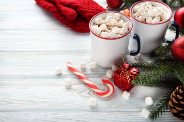 Kapuçino hatmi kupalar ve ahşap masa üzerinde köknar ağacı dalları ile