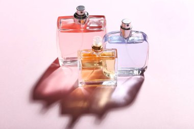 Pembe arka planda parfüm şişeleri