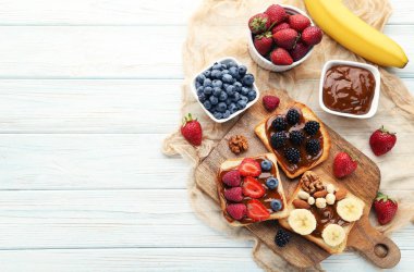 Tost ekmeği kahverengi kesme tahtası üzerinde çilek ile