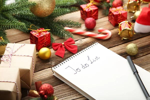 在记事本上做列表 用木桌上的圣诞装饰品 — 图库照片
