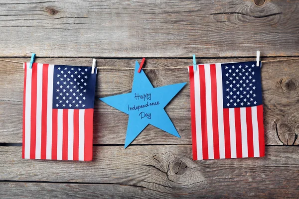 American flags and paper star with inscription Happy Independence Day