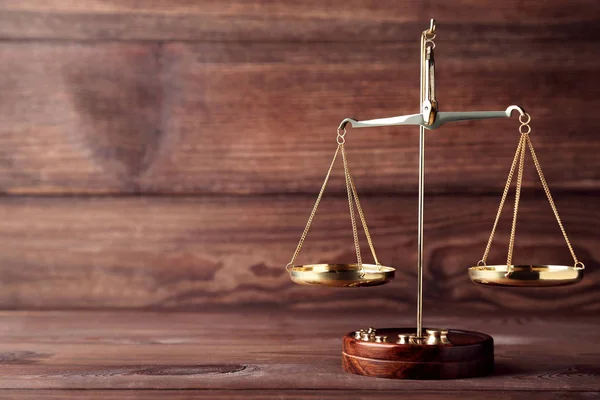 茶色の木製のテーブルの上の正義のスケール — ストック写真