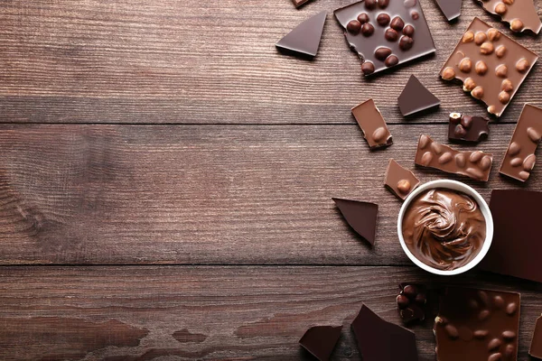 Coklat Potongan Dengan Kacang Dan Mangkuk Atas Meja Kayu — Stok Foto