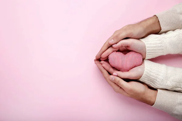 Vrouwelijke Mannelijke Hand Met Rode Stof Hart Roze Achtergrond — Stockfoto