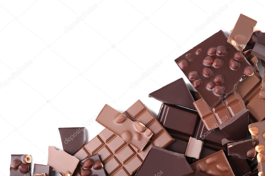 Chocolate pieces and hazelnuts on white background