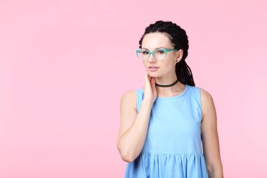 Pembe bir arka plan üzerinde mavi elbiseli Genç kadın